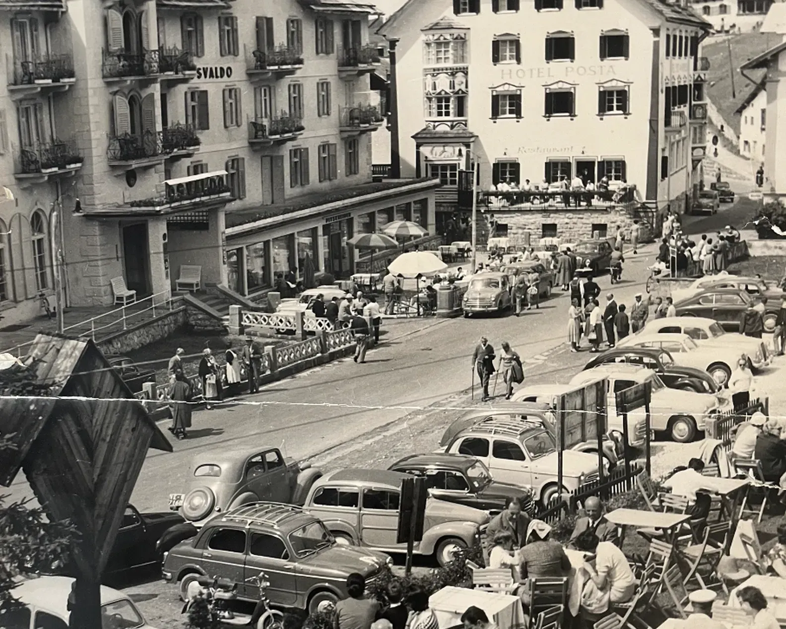 View of the terrace and square in front of Hotel Oswald, filled with people, highlighting how the hotel has always been a landmark for the local community.