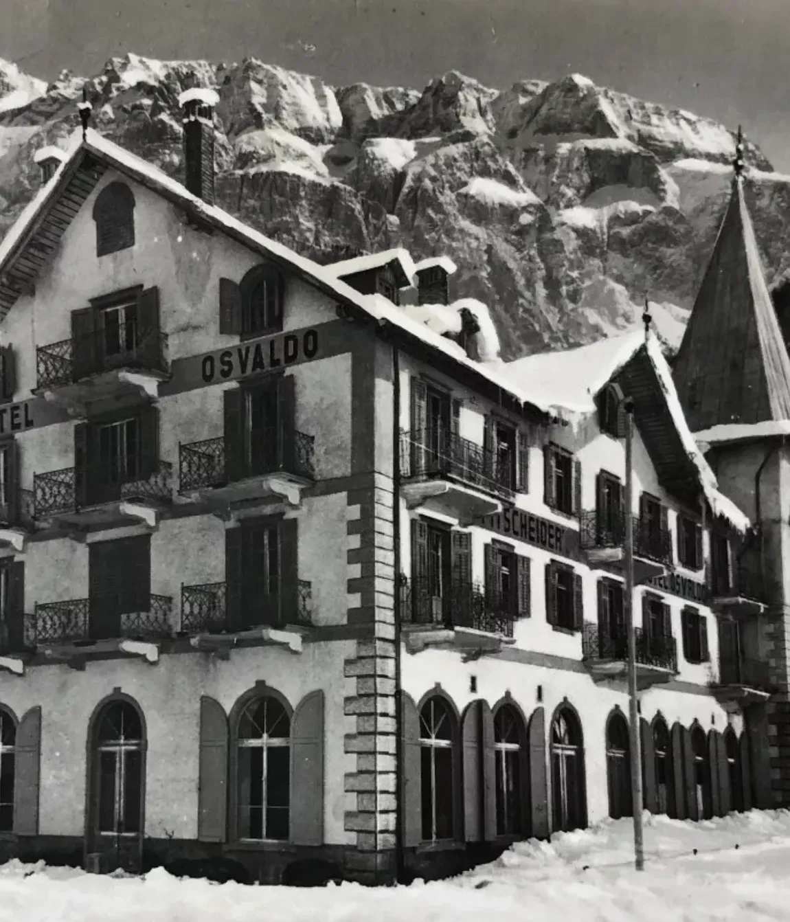 First winter season of Hotel Oswald, featuring the building and its iconic turret, with the roof covered in snow.